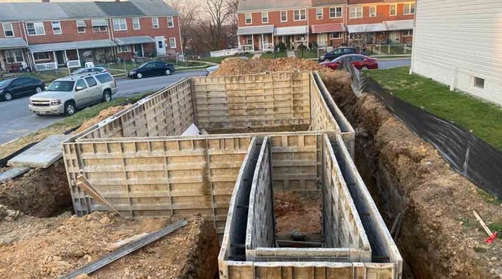 Wooden forms set up for pouring concrete, part of the foundation work at a building site.
