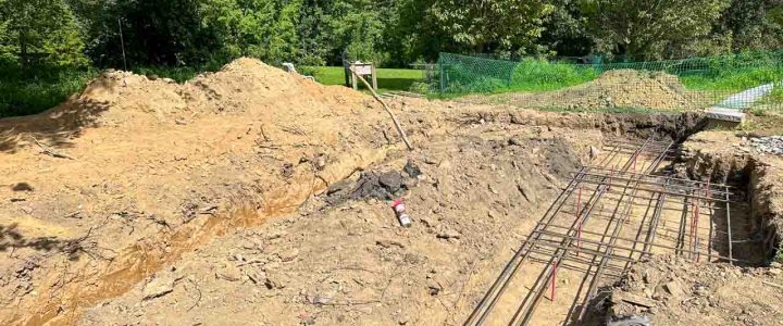 An excavated area with a steel reinforcement grid in place, ready for concrete pouring.