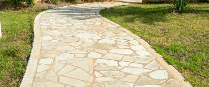 A beautifully laid stone pathway winding through a landscaped garden.